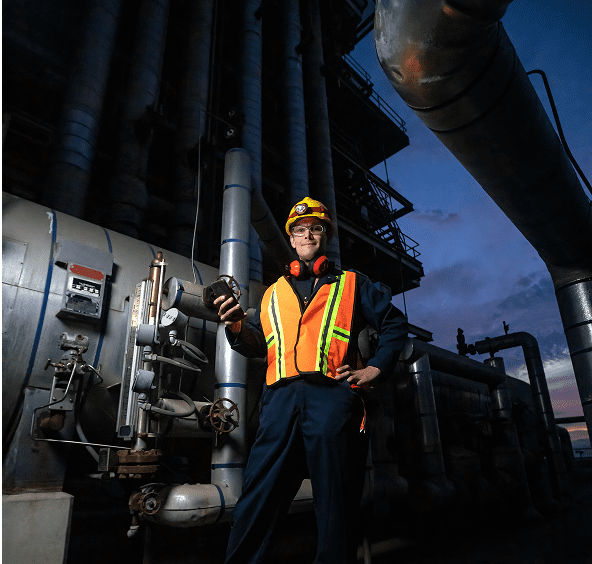 Factory worker holding a device in plant
